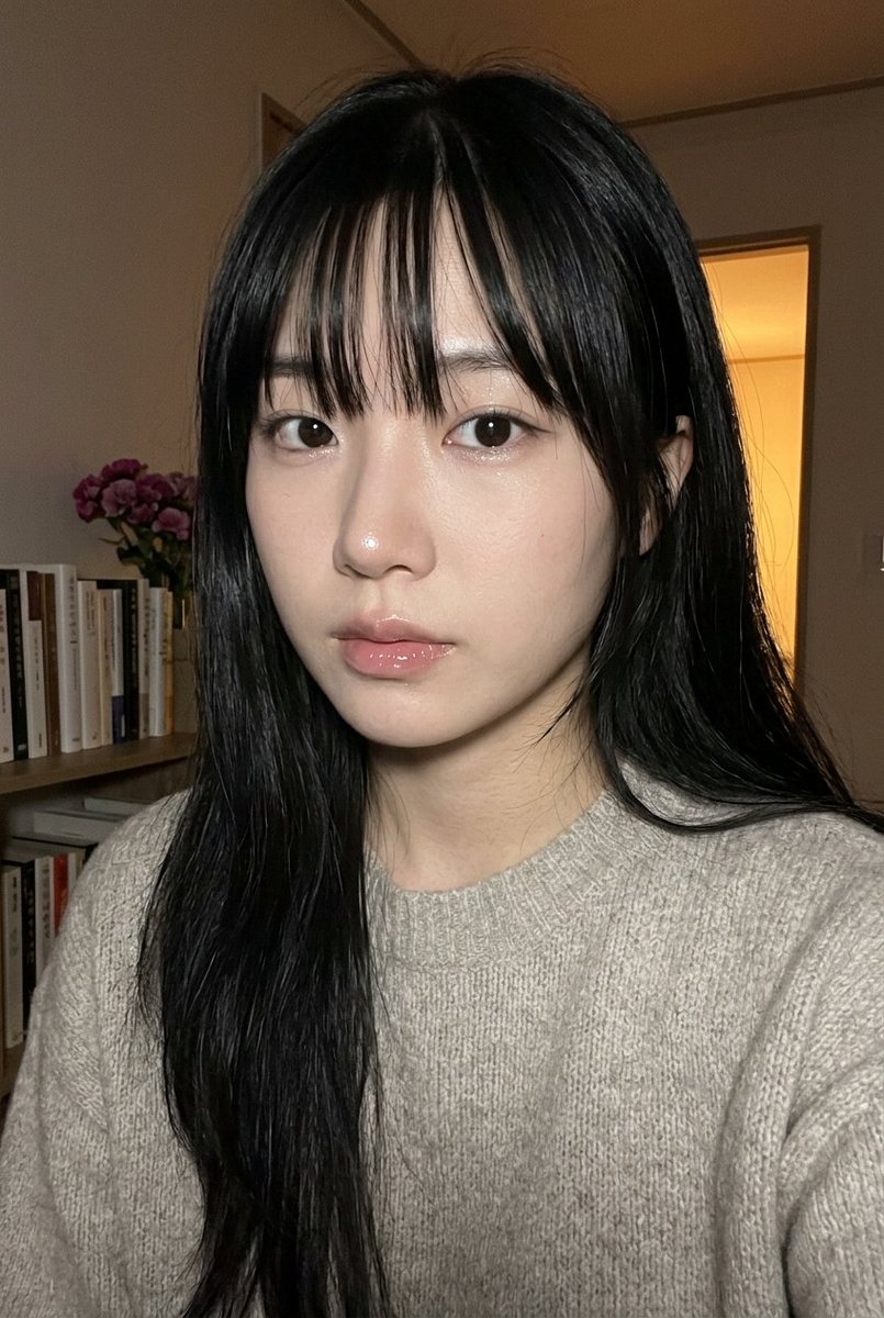 { "subject": { "description": "一张贴近的、写实风格的社交媒体式人像特写，主体是一位长黑发、刘海厚重的年轻女性，在夜晚室内拍摄…