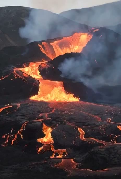 一张火山地貌的照片,有流动的熔岩,强调其原始的力量和戏剧性的对比。 视频提示:一个巨大的火山巨人从火山中走出来。"人类,我是来修复你们的!"https://t…