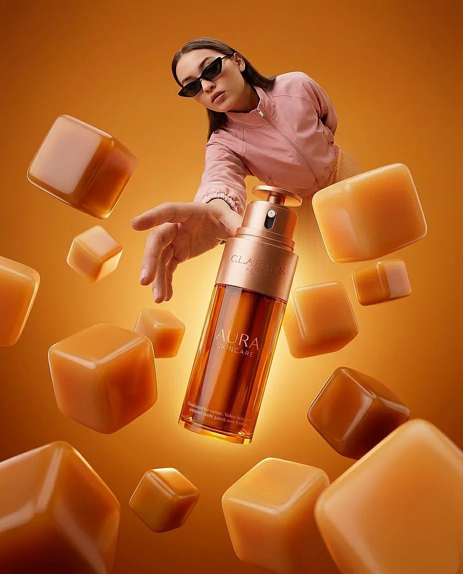 “超现实时尚产品摄影:一只巨大的琥珀色护肤品瓶(Clarins Aura)放置在一个极简盒子房间内的橙白格子地板上,温暖的纯橙色灯光,一位时尚女性戴着太阳镜、穿着桃色夹克伸手去够…