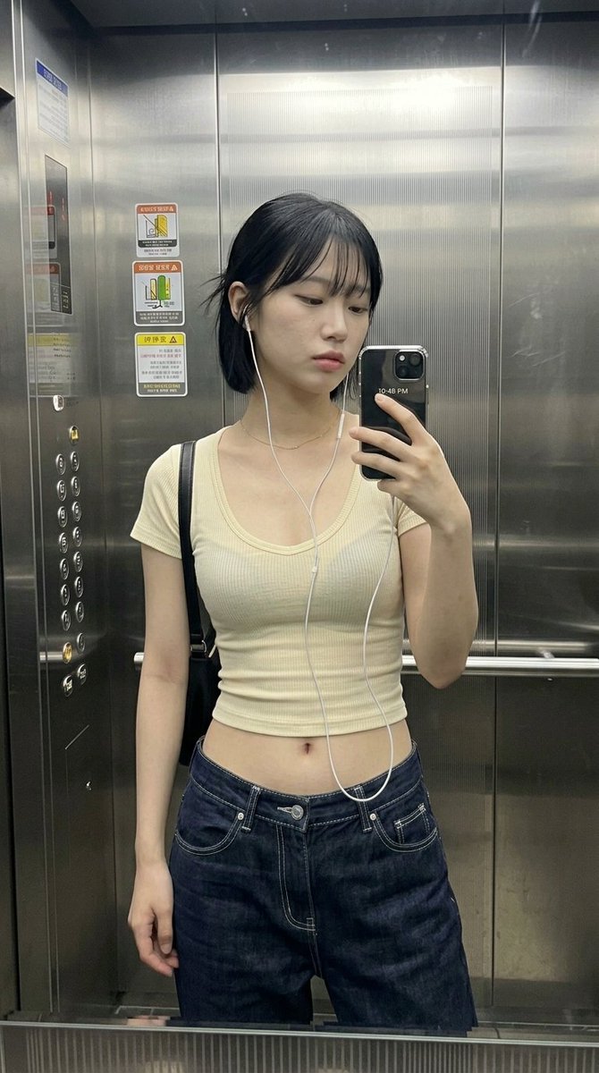 { "subject": { "description": "一位年轻女性在电梯里随意地对着镜子自拍。", "mirror_rules": "右手持手机，部分…