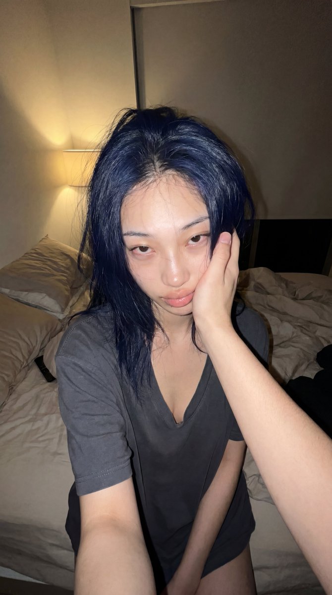 一张写实风格、真实的深夜卧室快照。从男朋友的视角俯拍，他右手温柔地托住他韩国女友的脸。她的外貌和造型强烈类似《火影忍者》中的日向雏田。她的头发凌乱地散落着，几…