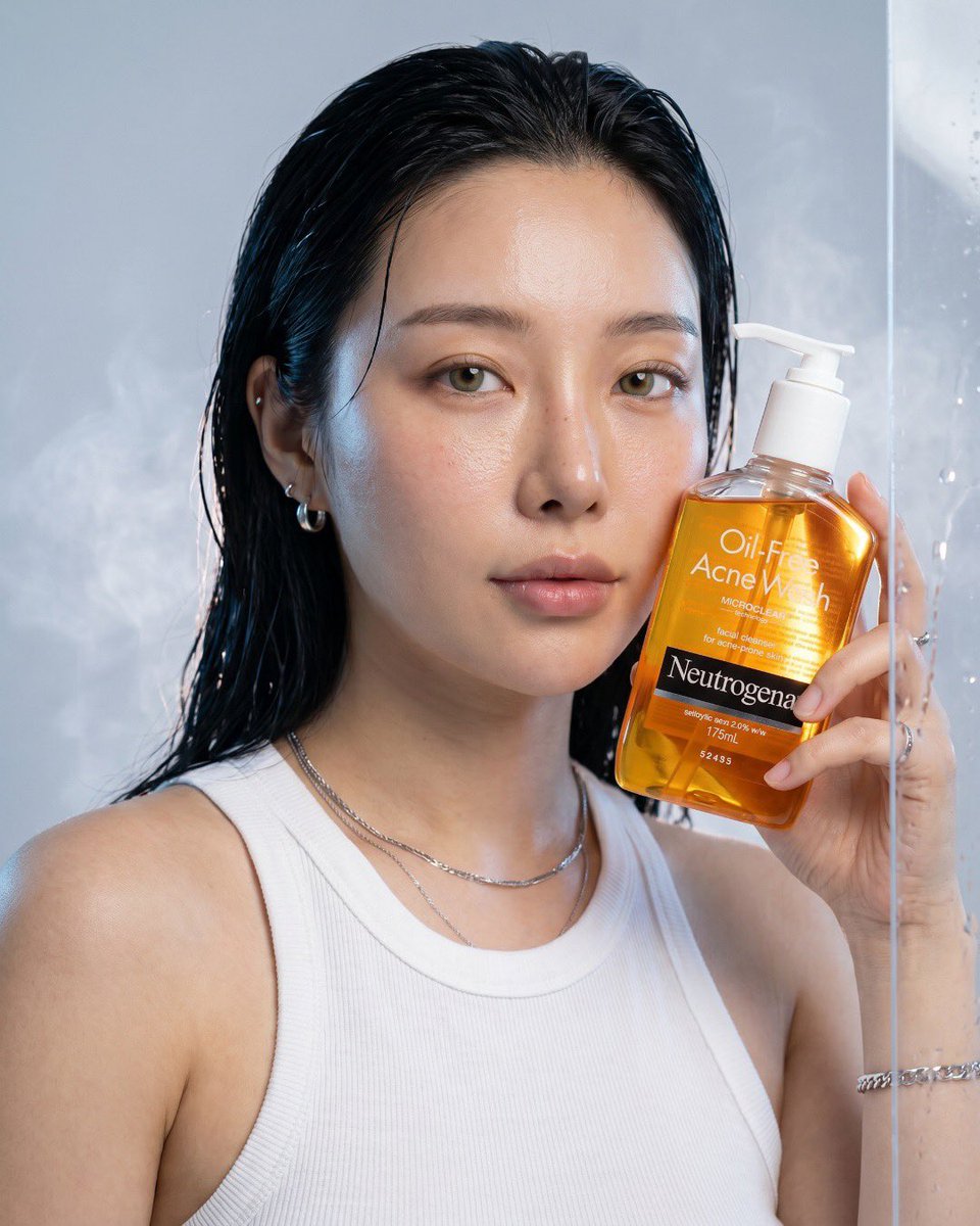 超写实奢华护肤品广告,Neutrogena 无油祛痘洗面奶,高端商业产品摄影,透亮琥珀色洁面瓶配透明按压泵,漂浮的水花与晶莹水珠,新鲜芦荟切片,柑橘类水果,薄荷叶,反光湿润表面…