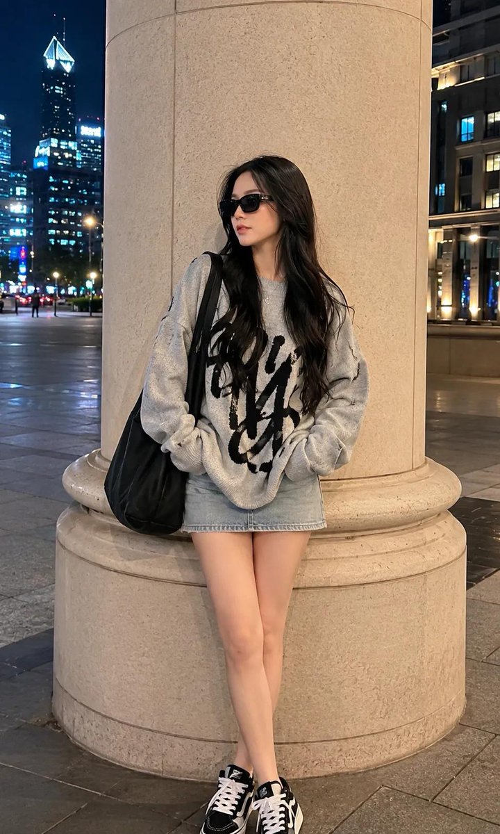 超写实全身时尚肖像:一位美丽的年轻女性,夜晚站立在豪华都市商业区一根高大的米色建筑立柱旁,神态轻松随意。面部轮廓柔和女性化,肌肤白皙无瑕,身材比例优雅,气场自信甜美,佩戴黑色矩形…