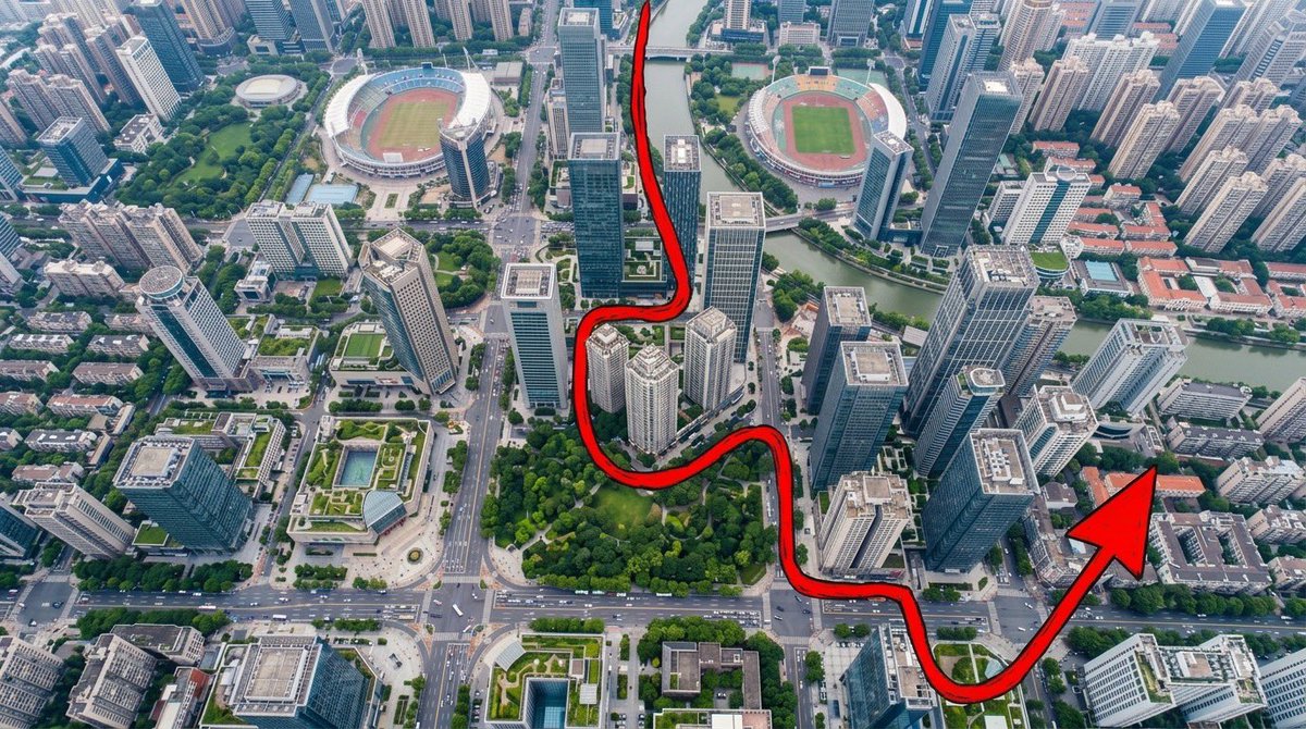 “一张从正上方拍摄的、写实风格的航拍无人机照片，呈现一座密集、充满活力的现代城市：摩天大楼鳞次栉比，城市街区排列有序，街道上布满小巧的车辆，建筑之间散布着大片…