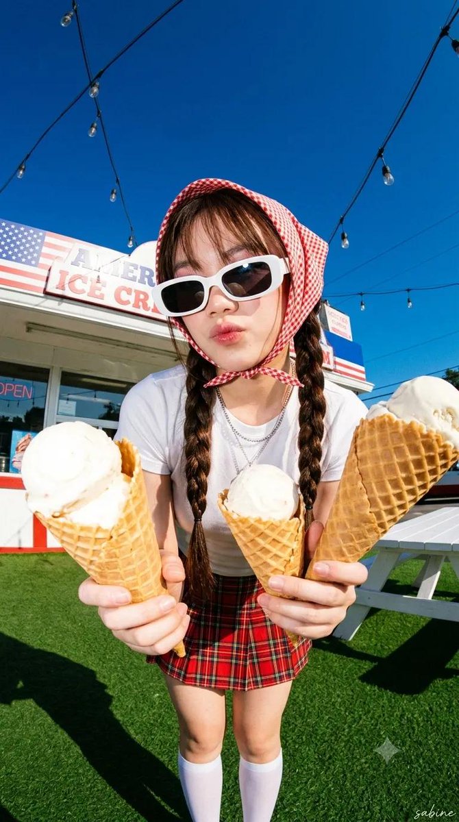 超写实Y2K夏季时尚大片,年轻女性身穿白色修身背心、红色格纹迷你裙、下巴下方系着红色方巾头巾、佩戴白色方形复古墨镜、银色层叠项链、及膝白色长袜、深棕色长双辫配…