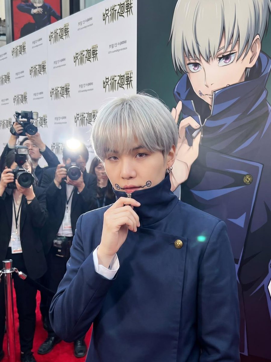 超写实真人版动漫改编首映礼活动，年轻明星完美Cosplay《咒术回战》角色，置身华丽红毯之上，奢华媒体活动，专业摄影师手持闪光灯疯狂拍摄，背景是与Cosplay角色相匹配的动漫角…
