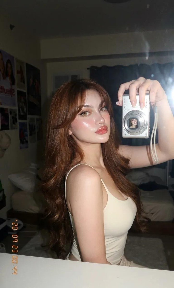超写实特写美女肖像,一位令人惊艳的年轻女性,采用 iPhone / 数码相机美感的直接机顶闪光灯拍摄于昏暗的室内环境。华丽自然的美女镜头,带柔和镜头光晕、微妙闪光绽放、皮肤光泽反…