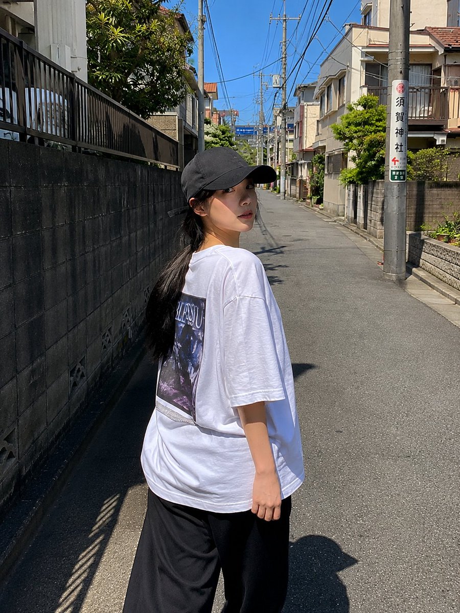 一位超美的年轻日本女性,拥有无瑕陶瓷般肌肤、自然红润的脸颊、光泽粉嫩的嘴唇、大而闪亮的杏仁眼,还有乌黑丝滑长发在风中肆意飞扬。她身着醒目的 oversized 亮红色校队夹克,内…