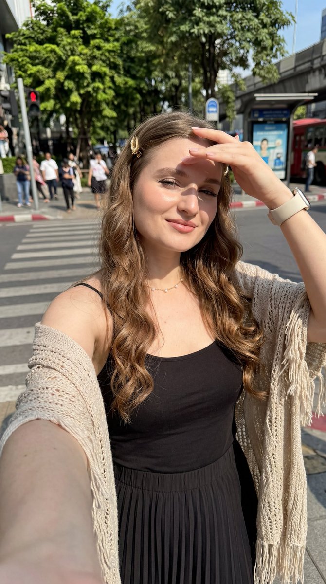 超写实 8K 近距离自拍,年轻欧洲女性,略仰拍视角,手臂伸展握着手机,明亮晴朗的白天,直射的强烈阳光,锐利的面部阴影,艺术化的高对比度光影,充满活力的强烈氛围,轻微温柔的微笑,白…