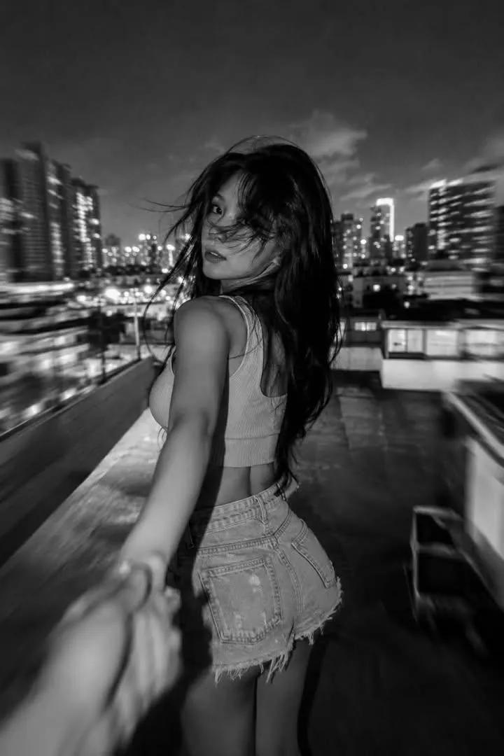 创作永恒的黑白电影感人像，运用戏剧性光效、胶片颗粒、情感氛围以及标志性的编辑美学。黑白光影色彩，胶片质感，人物质感，独特视角，一位[美丽的人物]，搭配[特定的发型或时尚造型]，置…