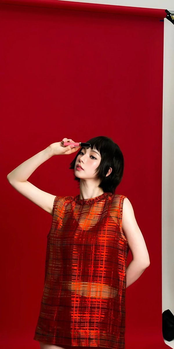 高端时尚编辑大片美妆广告,画面中是一位优雅的东亚女性模特,拥有无瑕瓷器般肌肤、水润自然的双唇、柔和的蜜桃色腮红以及细腻的微翘眼线。利落短款黑色波波头发型,搭配轻盈碎刘海。她身穿一…