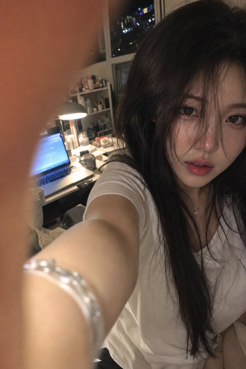 { "subject": { "description": "一位成年女性模特出现在一张近距离高角度自拍风格的照片中。她的脸靠近镜头,位于画面右侧,一只手臂伸…