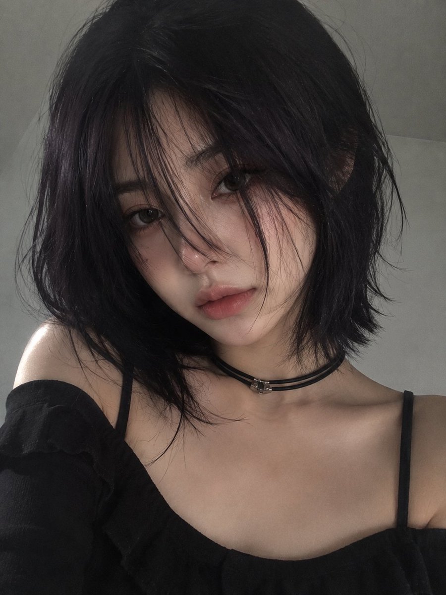 柔和极简风格的人像肖像:一位年轻女性,留着光滑的深紫黑色波波头与细长的碎刘海,刘海部分遮住一只眼睛,她轻轻地将一朵白色雏菊花举在唇前。苍白瓷器般的肌肤上带着淡淡自然的红晕,深灰绿…