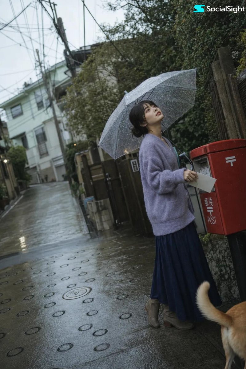 一张电影感、怀旧风格的生活摄影照片，拍摄于日本雨后湿漉漉的住宅街道。一名留着利落齐下巴短波波头的年轻日本女性站在一辆经典的妈妈骑（mamachari）自行车旁，一只手轻轻搭在车把…