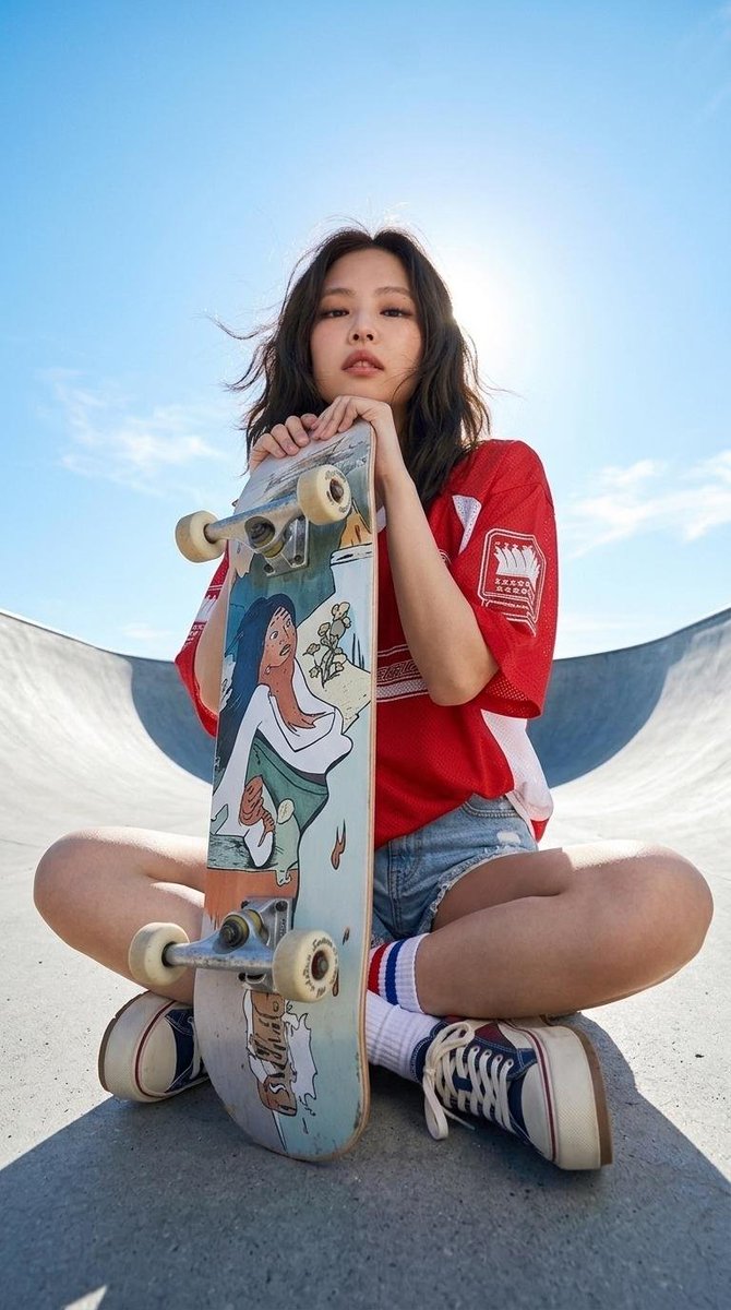一位时尚年轻的东亚女性,神情自信冷酷,深色齐肩短发被微风轻轻吹拂。她身穿一件宽松的复古风格红色运动球衣,侧面带有白色拼接,胸前印有醒目的图形字母。下身搭配高腰浅色水洗牛仔短裤,带…