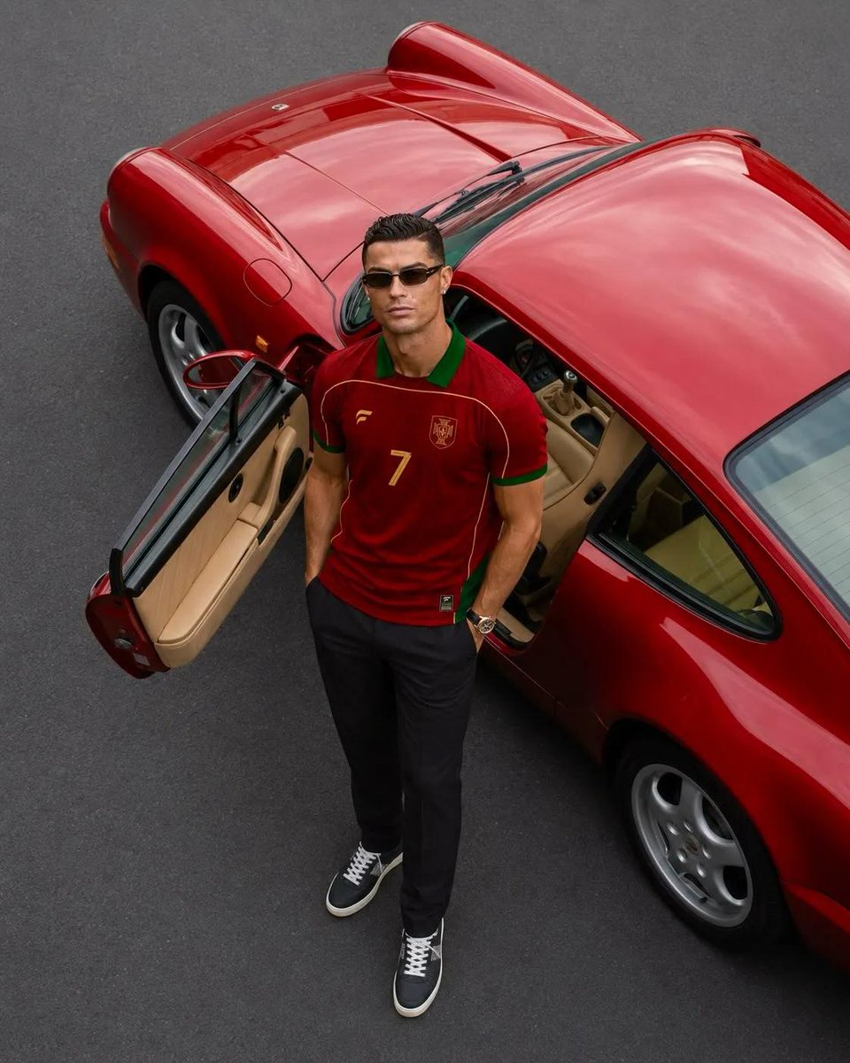 超写实奢华运动时尚大片，主角为克里斯蒂亚诺·罗纳尔多（Cristiano Ronaldo），保留其标志性的面部特征、运动体型、利落发型与自信气质。他身穿一件高级复古葡萄牙足球队球…