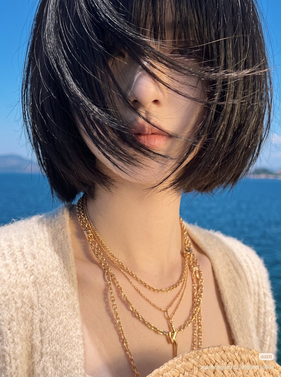 东亚年轻女性审美生活方式肖像,齐刘海黑色短发波波头,强烈的海风戏剧性地将所有头发吹过面部完全遮住眼睛,营造神秘的无脸美学,嘴唇和鼻子透过被风吹起的发丝若隐若现,身穿超大柔软米色针…