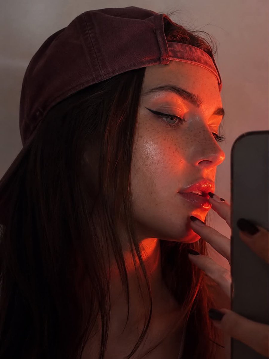 不要改变你的特征 3:4 长宽比 一张年轻女性的特写肖像，呈现锐利的侧面轮廓，背景为浅色、中性色调。她戴着一顶稍微偏大的浅酒红色棒球帽，帽子反戴，帽檐向上翘起…