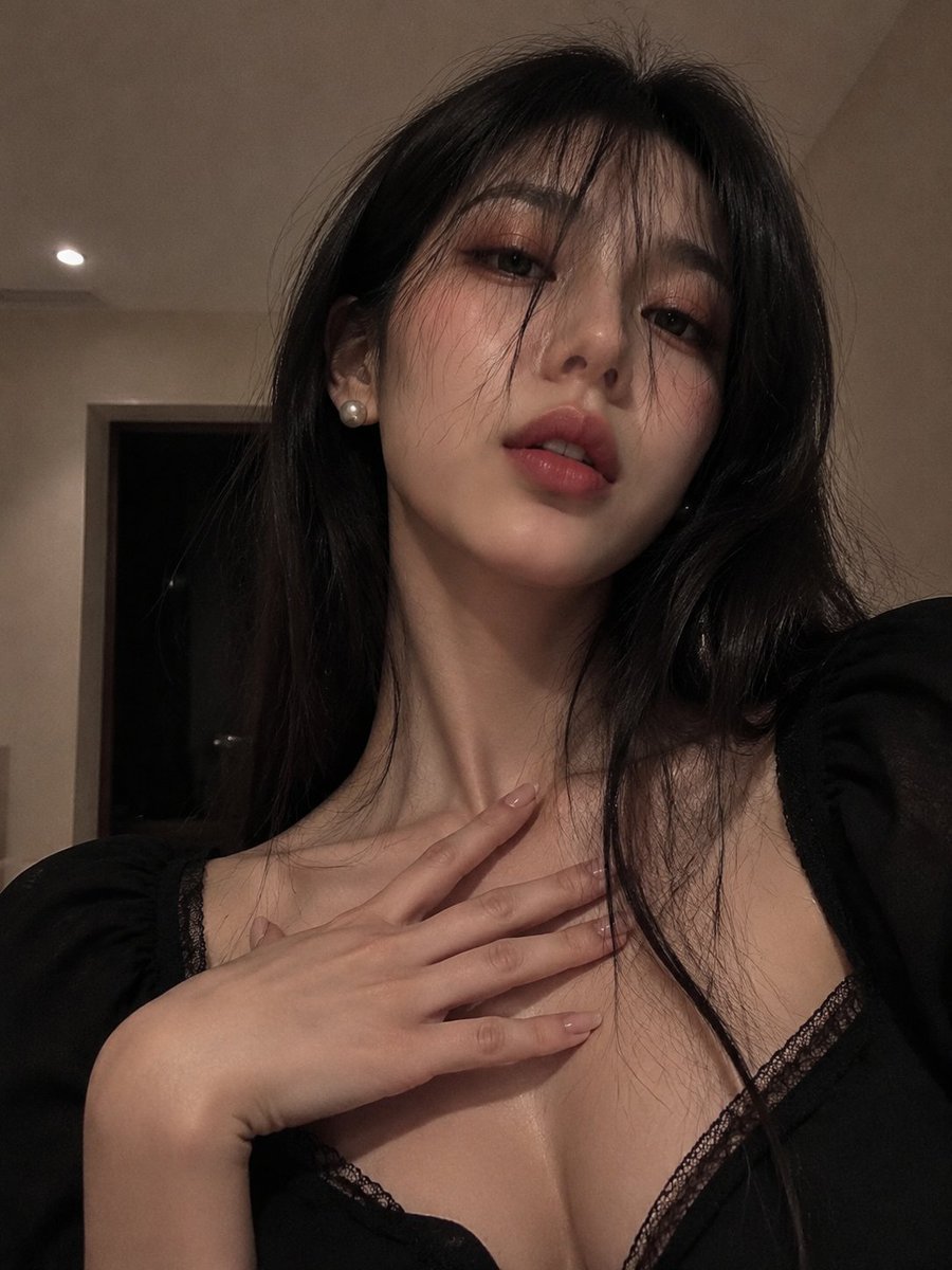 年轻成年女性的正面自拍。紧贴胸部的裁切构图,略带仰拍角度,24-28mm镜头。近黑色的长直发,零碎刘海垂在眼前。半阖的眼神,微启的双唇。东亚编辑级妆容,玫瑰粉…