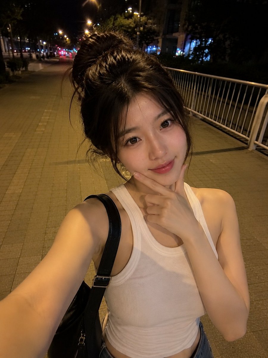 夜晚,一位美丽的东亚年轻女性在安静的城市人行道上户外行走的真实感智能手机自拍。她拥有瓷白肤色、闪亮的大眼睛呈深棕色、小巧笔挺的鼻梁、自然有光泽的粉嫩双唇,以及精致年轻的面部特征…