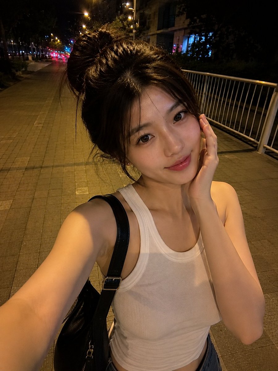 夜晚,一位美丽的东亚年轻女性在安静的城市人行道上户外行走的真实感智能手机自拍。她拥有瓷白肤色、闪亮的大眼睛呈深棕色、小巧笔挺的鼻梁、自然有光泽的粉嫩双唇,以及精致年轻的面部特征…