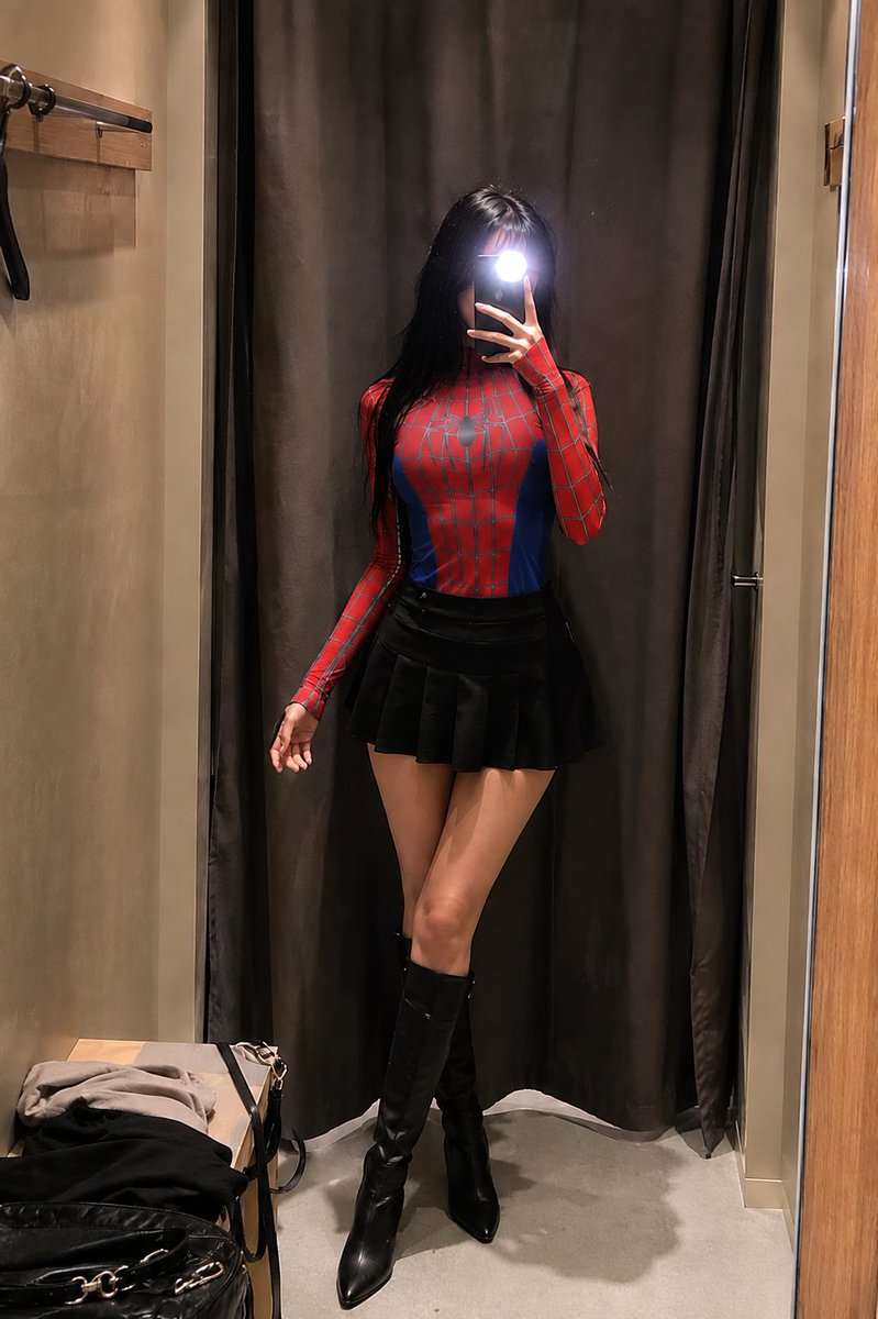 1- 一位身材纤细的年轻女性在试衣间对着镜子自拍，身穿紧身红蓝蜘蛛主题紧身连体衣（灵感来自蜘蛛侠），黑色长直发配齐刘海，手持手机闪光灯遮住面部，氛围感打光，高细节，逼真皮肤质感…
