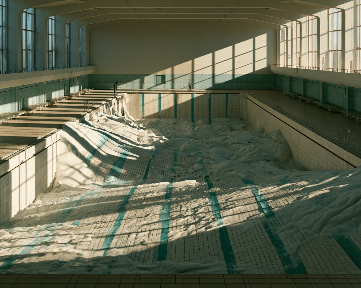 宽幅建筑摄影，废弃的中世纪室内游泳池，池中充满 [POOL SECRET] 而非水，这种替代物以戏剧性不同的高度填满铺贴瓷砖的泳池槽，同时让原有的青绿色泳道线部分可见，一个成年人…