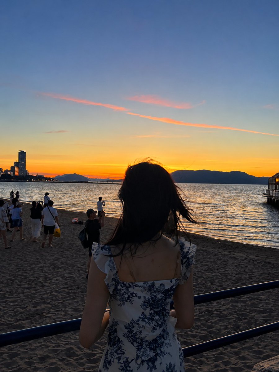 超现实电影感旅行照片：一位年轻的东亚女性站在沙滩上，沐浴在令人屏息的日落中，采用竖向 3:4 构图。她身穿一件精致的白色连衣裙，点缀着细腻的蓝色花卉印花，肩带为荷叶边设计，整体剪…