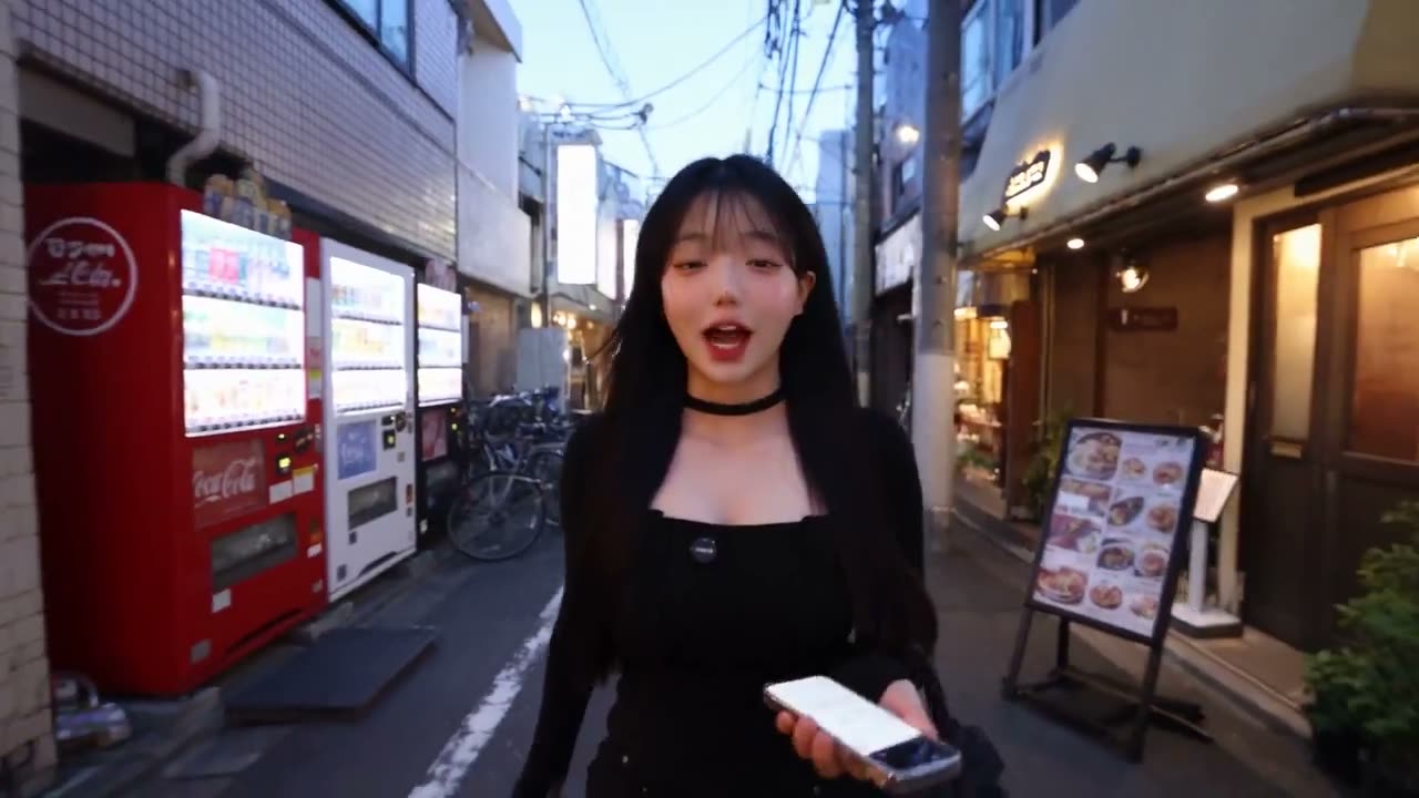 超写实智能手机美食 vlog，背景设定在日本东京一个迷人的街区。整个视频必须看起来像是由一位真实的女性创作者用现代旗舰智能手机真实录制的，而不是电影化制作或…