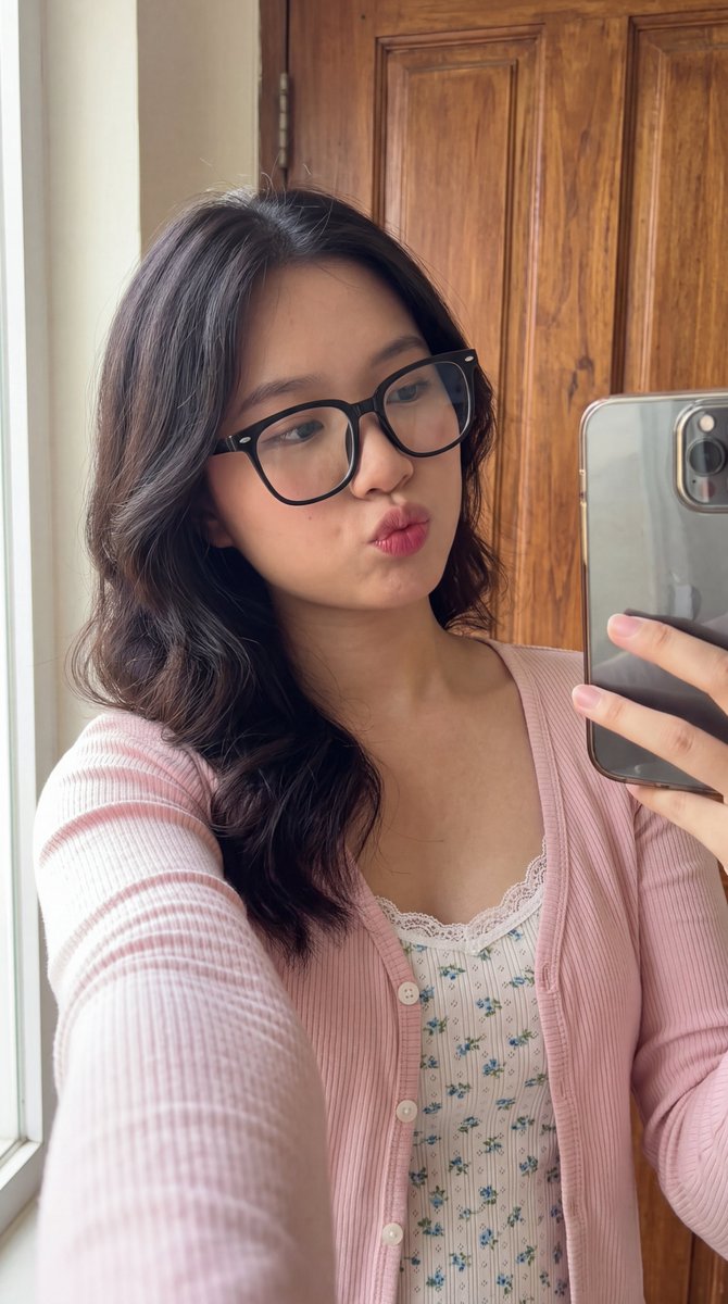 [Higgsfield 营销工作室图像提示] ar 9:16 4K High 一位年轻东亚女性的近距离自拍肖像，长长的波浪状深棕色头发垂落在一边肩膀上。她戴着一副大号黑框眼镜，俏…