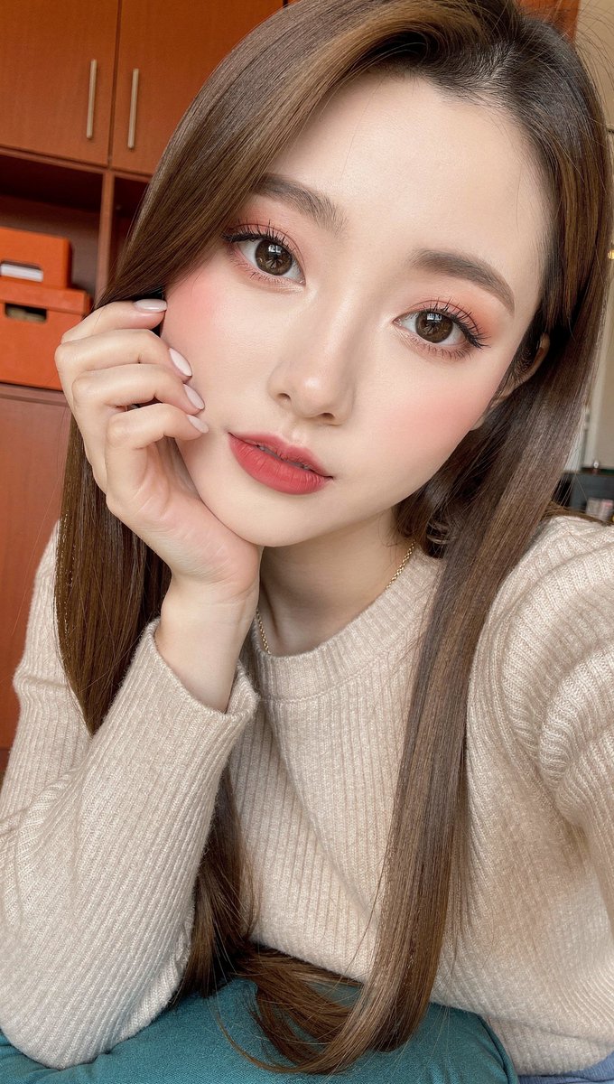[FLUX.2 Pro 提示词] ar 9:16 2K 一张年轻东亚女性的近距离自拍式肖像，她有着长而顺直的丝滑长发，柔和的暖棕色挑染垂落在肩头。她拥有白皙的瓷感肌肤、天然妆容下…