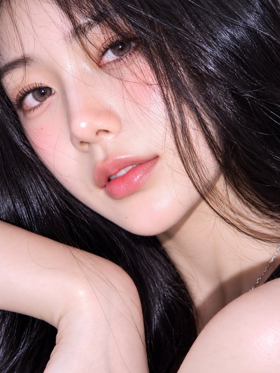 超逼真、令人无法抗拒的抢眼抓拍肖像照:一位魅力十足的年轻女子侧身躺在浓郁的青绿色(绿松石蓝)表面上,以亲密的特写角度拍摄,构图略微倾斜。她一头如丝般顺滑的乌黑长发自然地在她头部周…