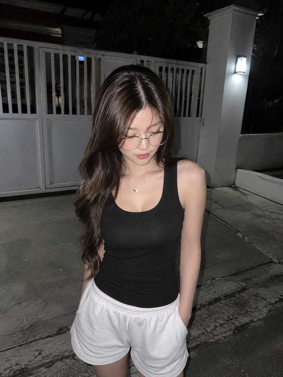 使用 GPT image 2 创建 提示 ↓ 一张真实的直闪抓拍夜景照片，主体是一位年轻的东亚女性，留着长而自然卷曲的深棕色头发，戴着时尚的细框金属眼镜，身着…