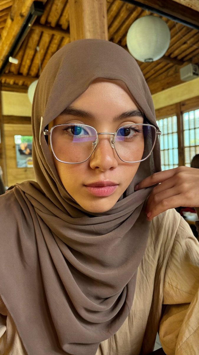 [Higgsfield Soul 2.0 提示词] ar 9:16 2K 一位年轻东亚女性的特写自拍照,她戴着一条灰褐色/柔和棕色的雪纺头巾,轻柔地披在面部和…