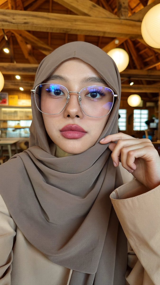 [Higgsfield Soul 2.0 提示词] ar 9:16 2K 一位年轻东亚女性的特写自拍照,她戴着一条灰褐色/柔和棕色的雪纺头巾,轻柔地披在面部和肩部周围,完全遮住头…