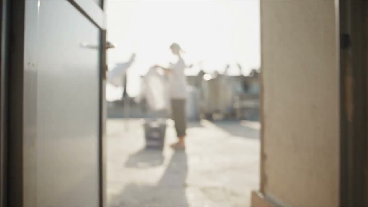 视频概念： 一段完全自然的30秒个人家庭录像，记录一位年轻女子在一个安静公寓屋顶上微风徐徐的午后做一件平常事。她晾晒刚洗好的衣服，发现一只袜子被风吹走了，然后…
