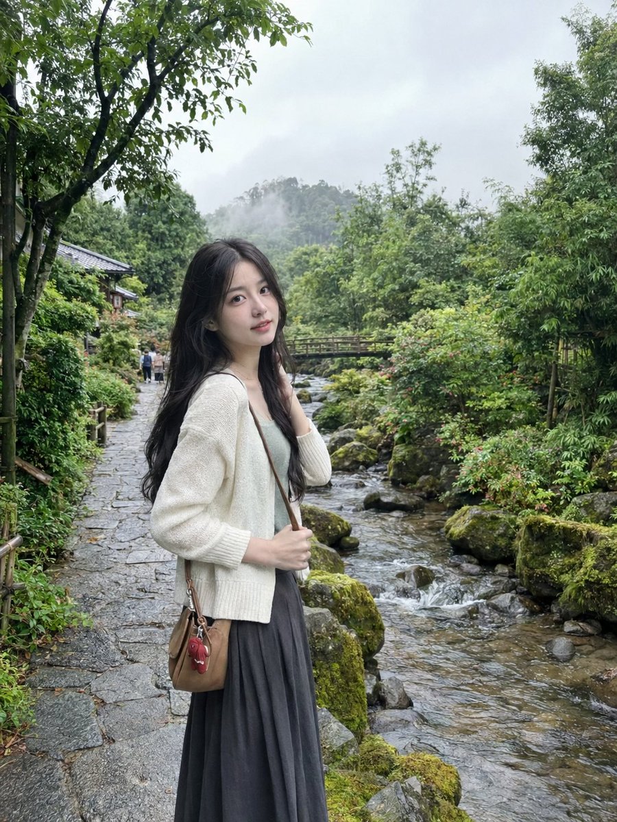 超写实自然智能手机摄影，竖向 3:4 比例，捕捉一位年轻东亚女性站在郁郁葱葱的日式庭院中一条雾气笼罩的山间溪流旁的安静石板路上的自然抓拍旅行肖像。 她拥有一头…