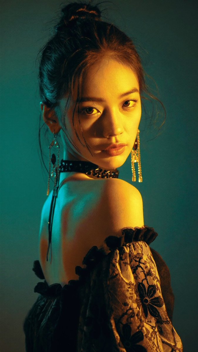 [Higgsfield Soul 2.0 Prompt] ar 9:16 2K 电影感人像摄影：一位年轻的东亚女性回头越过左肩望向镜头，表情强烈而略带神秘。深色头发盘成凌乱的高发…