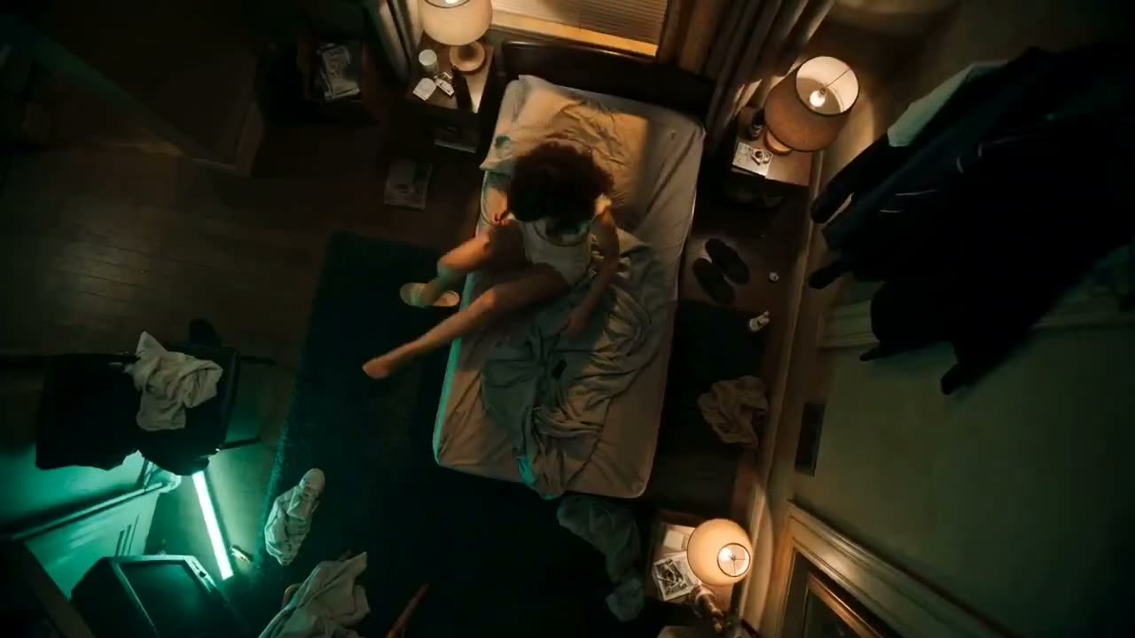 一位疲惫的女人，穿着宽松的背心 和睡眠短裤，缓慢的习惯性动作。眼线略晕，光脚，姿态沉重，神情疏离。 环境：狭窄拥挤的公寓，床铺未整理，衣服散落，狭窄的走廊，潮…