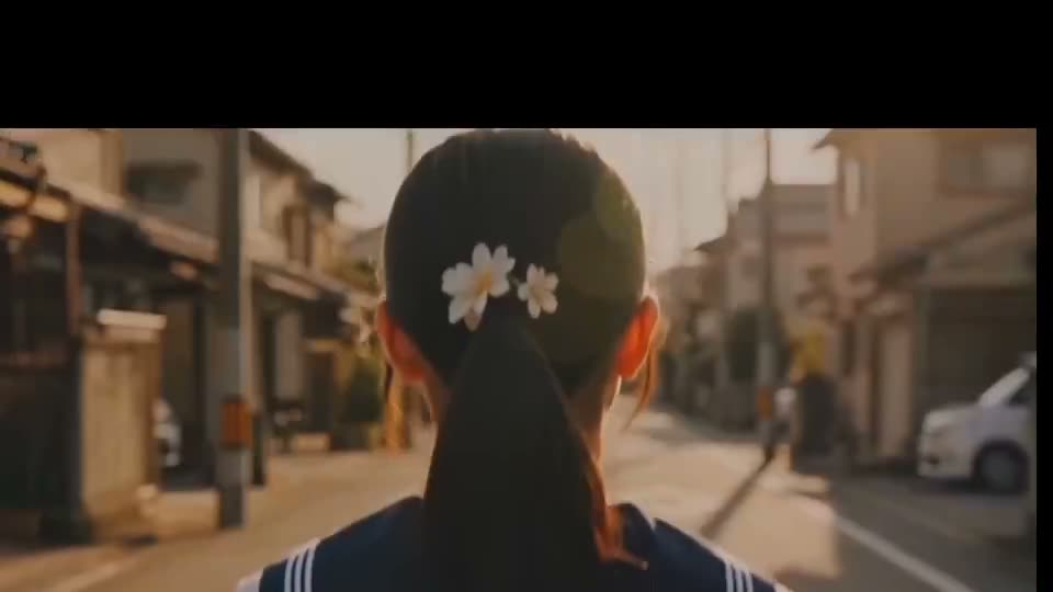 创作一段约20秒的日式电影风格场景：一位年轻的少女独自走在宁静的日本住宅街道上，沐浴在温暖的金色时刻阳光中，从背后视角拍摄，她缓缓走向一个铁路道口，背景中有一…