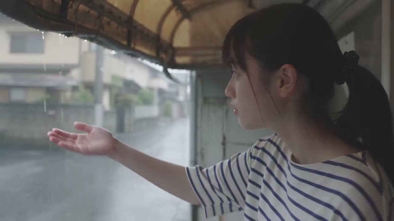 创作一段超写实电影感的日本生活方式 vlog，呈现一位年轻日本女性在安静住宅区享受宁静雨日的场景。 一位年轻女性，黑发整齐扎成马尾辫，身穿白底藏青色条纹 ov…