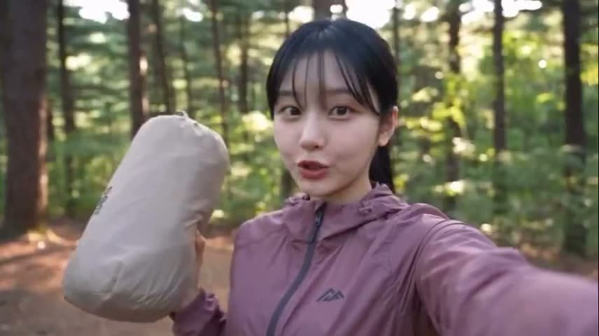 制作一段20秒的超真实电影感露营Vlog，主角是一位年轻日本女性，留着黑色直发和刘海，身穿藕粉色户外夹克。 场景1（0–4秒）：黄金时段在美丽松林中的自拍风格…