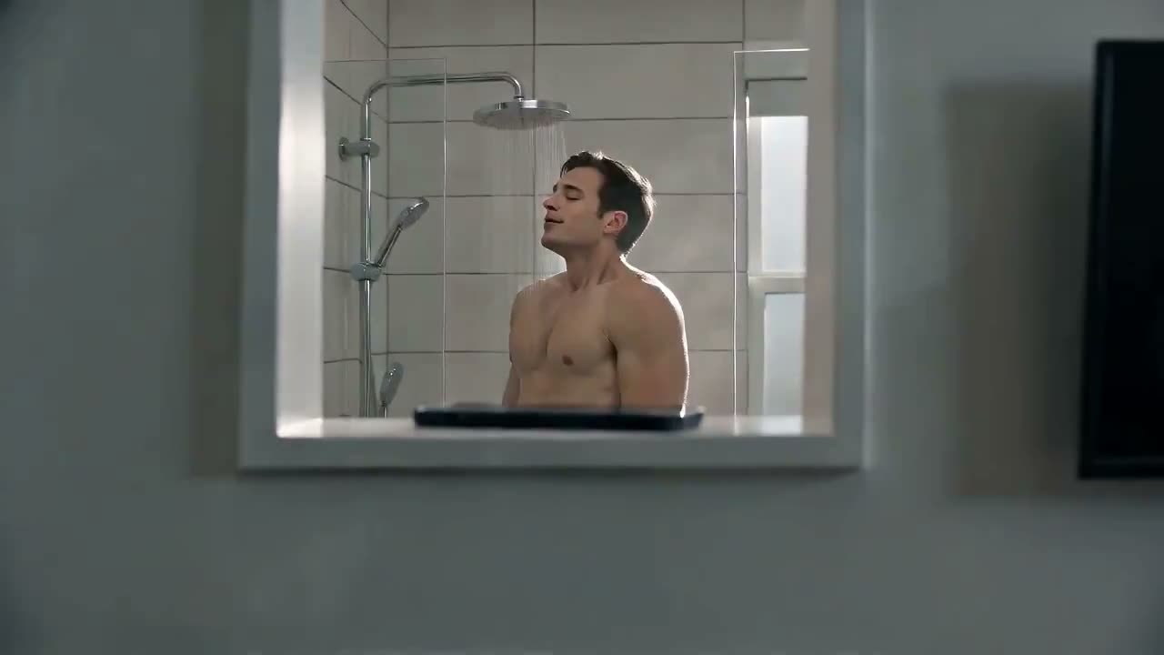 一个年轻人在一间现代公寓里正常淋浴，突然手机弹出一条快递通知。 他听到门铃响，迅速关掉淋浴，抓起一条毛巾，冲向门口。他小心翼翼地跑过地板，湿漉漉的脚留下一串细…