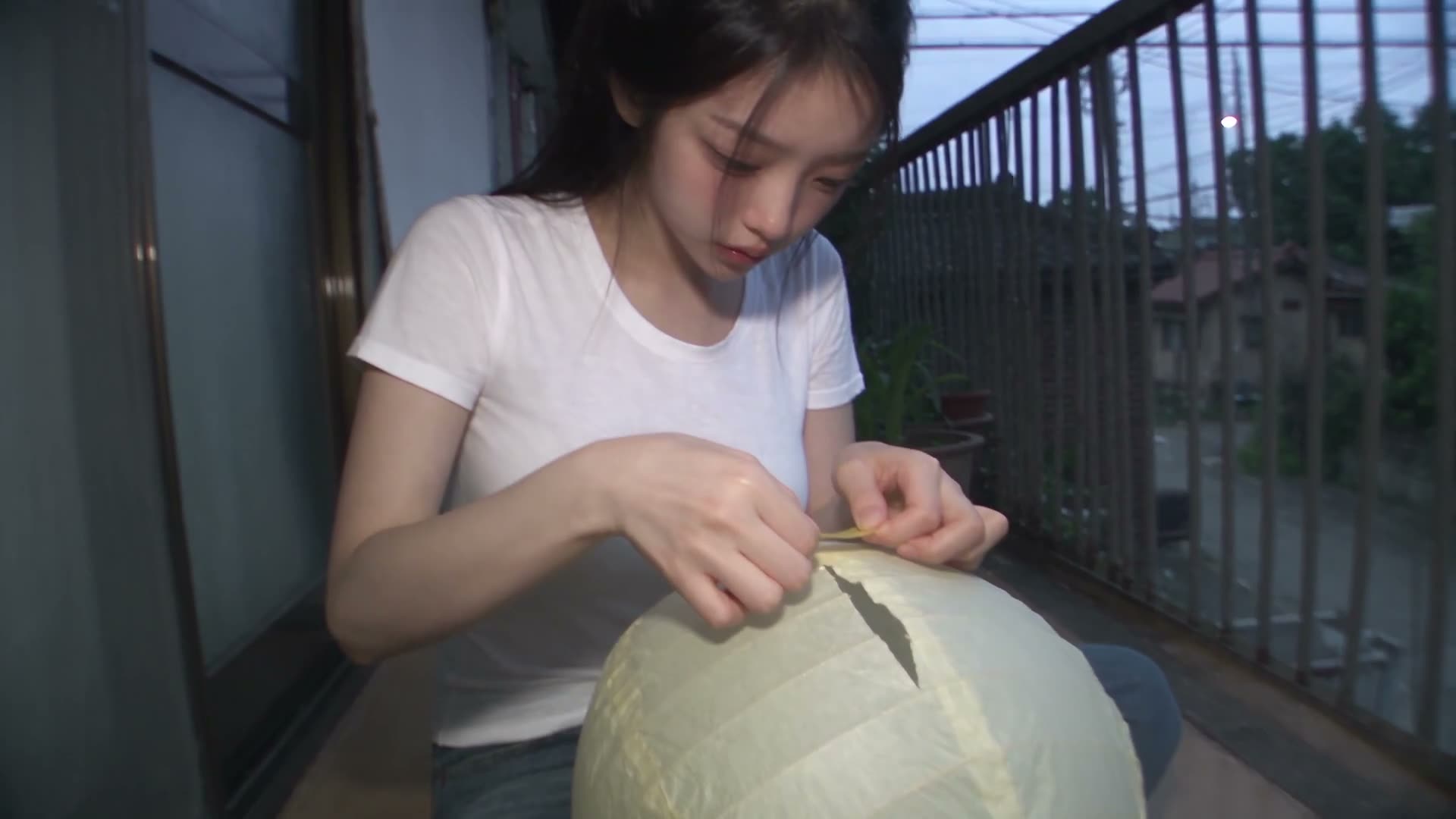 image = 主角。整段过程中必须完全保留她精确的面部、身份、发型、肤色、身材比例与服装。 真实的东南亚/韩国女性,2000 年代初的氛围。安静平凡的住宅街…