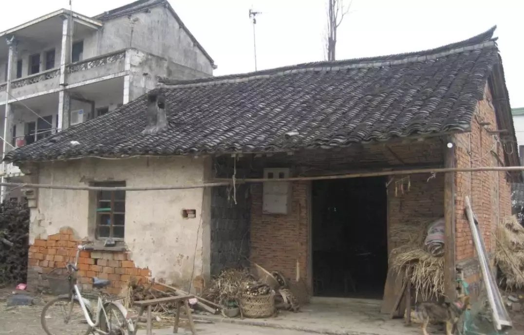 参考上传的老房子照片，以1:24比例精准复刻为博物馆级超写实实体微缩模型，严格还原建筑结构、屋顶、门窗、墙体及原始环境。精细呈现斑驳墙皮、风化砖瓦、裂缝、青苔…